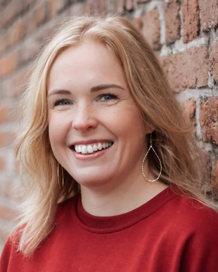 Portret van Evelien Vaags voor een bakstenen muur